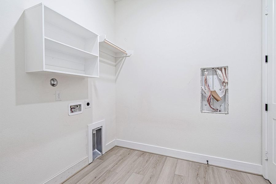 Dedicated laundry room with built-in cabinetry and ample workspace