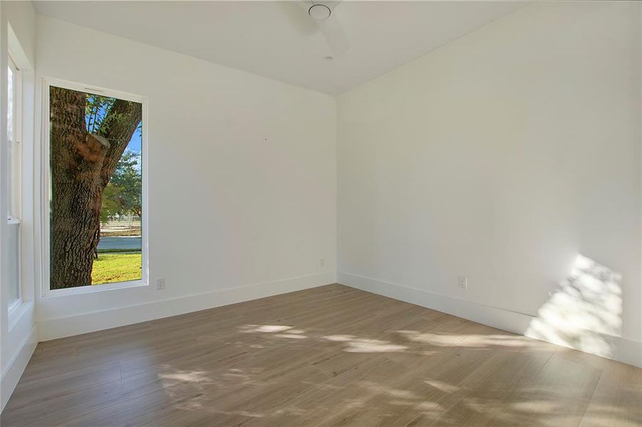 Empty room featuring ceiling fan and hardwood / wood-style flooring