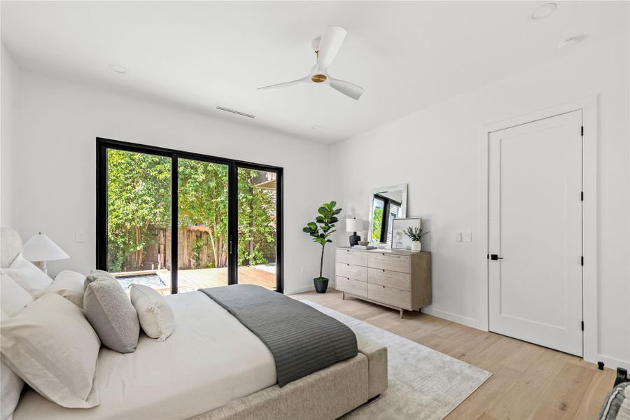 Bedroom with wood finished floors, ceiling fan, and access to exterior