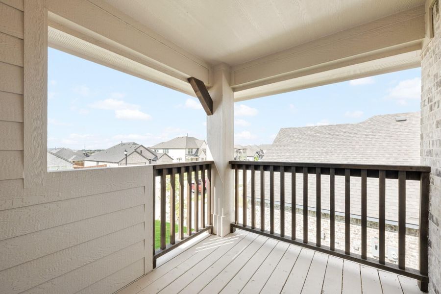Covered second-floor balcony with dark wood railing and neighborhood views on a sunny day