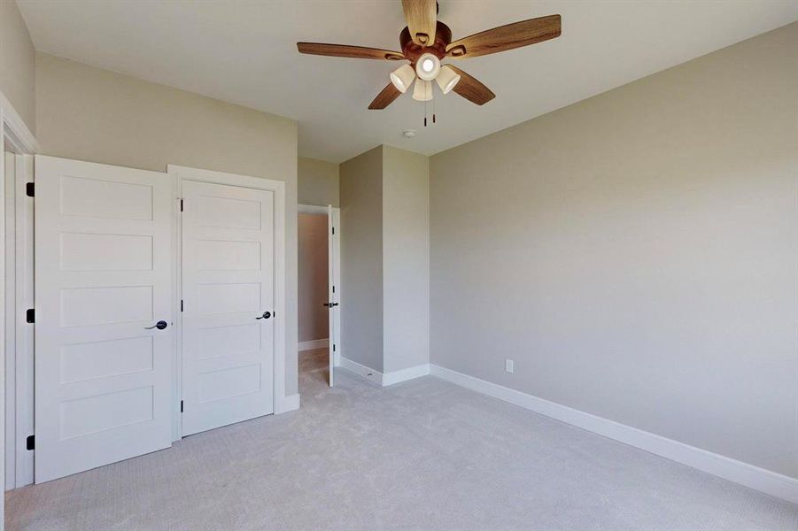 Unfurnished bedroom with carpet, ceiling fan, and a closet