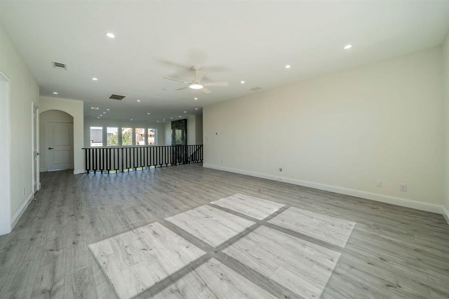 Unfurnished room featuring recessed lighting, light wood-style floors, arched walkways, and ceiling fan Unfurnished room featuring recessed lighting, light wood-style floors, arched walkways, and ceiling fan