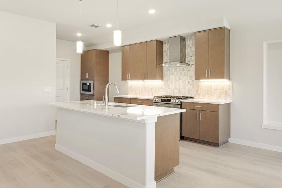 Modern kitchen with large white island, brown cabinets, stainless steel appliances, and tile backsplash