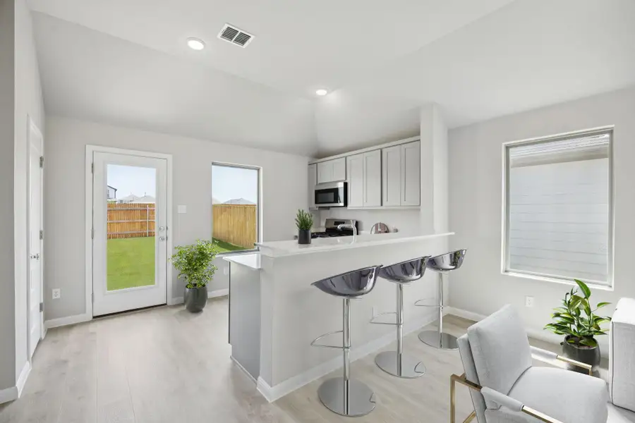 Kitchen featuring light wood-style floors, a kitchen breakfast bar, light countertops, a peninsula, and stainless steel appliances