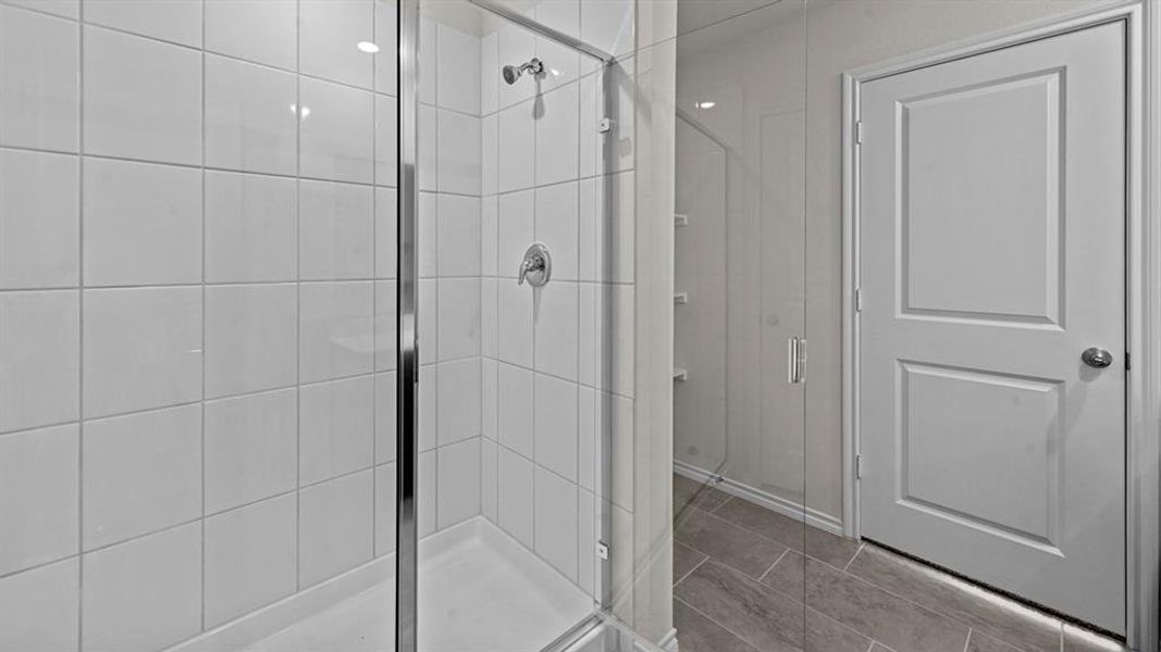 Bathroom featuring a shower stall and light tile patterned floors