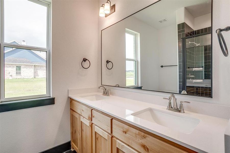 Bathroom featuring a healthy amount of sunlight and double vanity