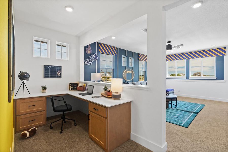 Home office with dark colored carpet, healthy amount of natural light, and recessed lighting