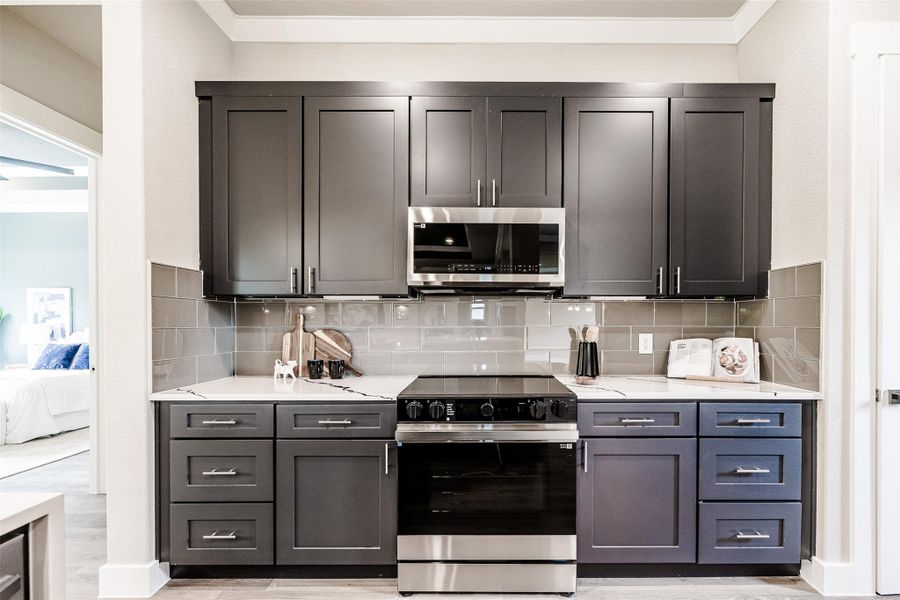 A streamlined culinary space boasts dark cabinetry and brilliant stone countertops. A streamlined culinary space boasts dark cabinetry and brilliant stone countertops.
