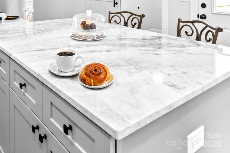 Huge island with marble counters & storage below.