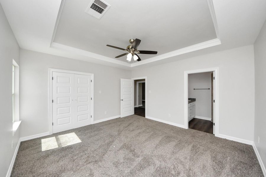 Here's another view of the gorgeous primary suite, a true sanctuary featuring a spacious closet with plenty of storage for all your wardrobe essentials. The attached ensuite bathroom is designed with both style and convenience in mind to meet your everyday needs - (representation photo).