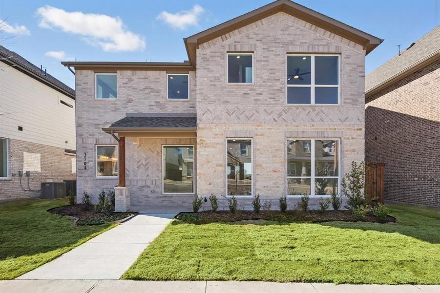 View of front of house featuring a front lawn, brick siding, and central air condition unit