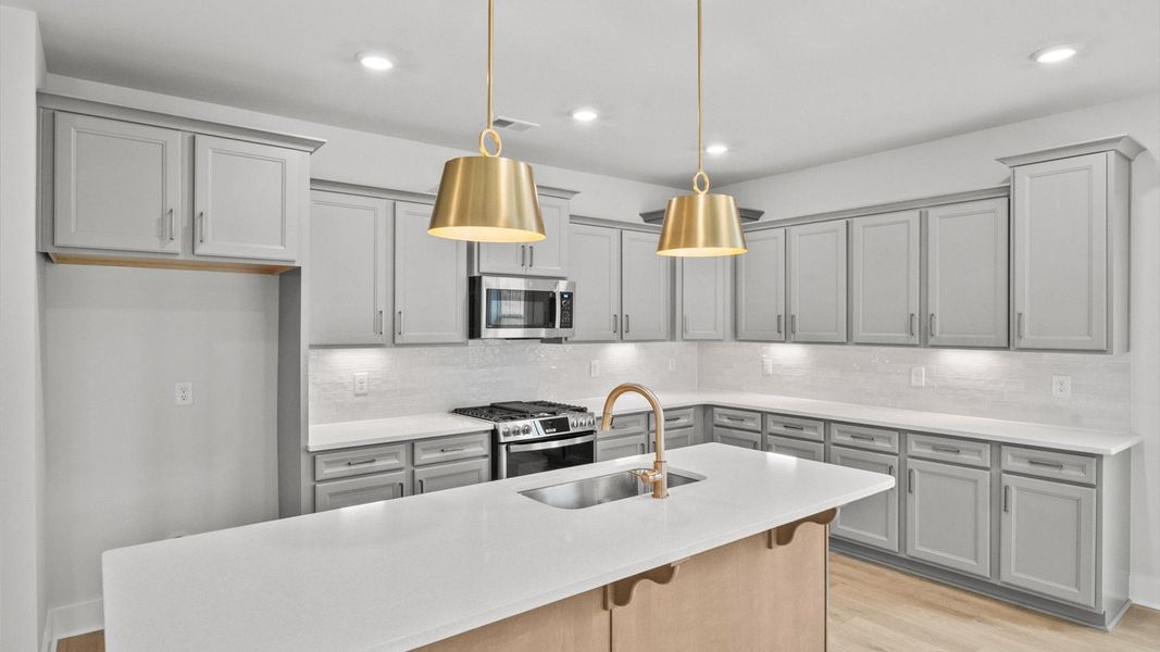 Memorable meals begin in this vibrant kitchen with pendant lighting and a thoughtfully designed island
