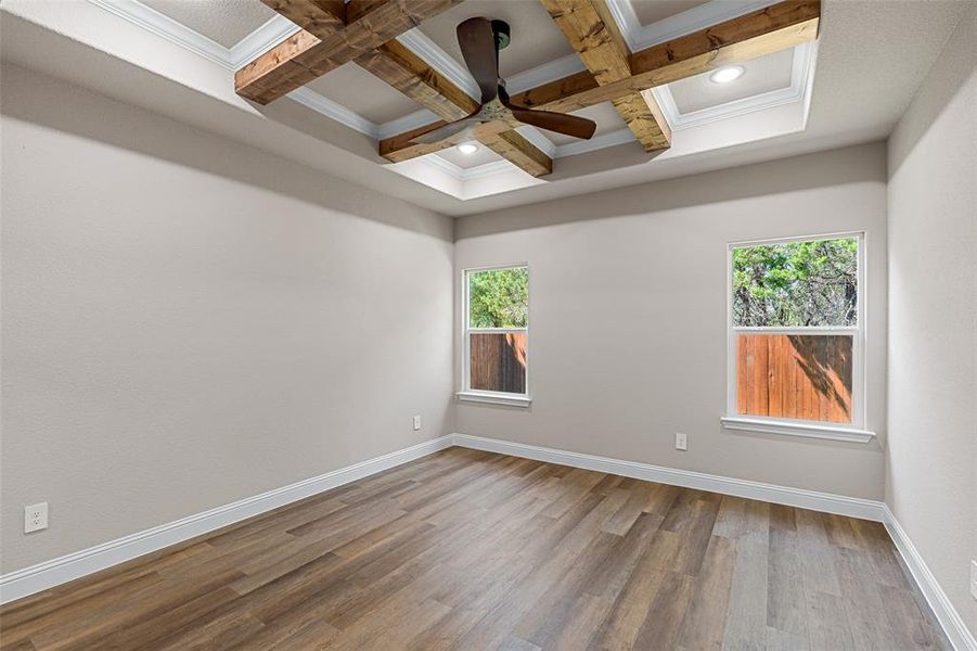 Spare room featuring ceiling fan, a wealth of natural light, coffered ceiling, and wood-type flooring