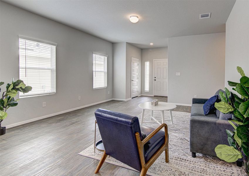 An inviting open-concept living area with abundant natural illumination and durable hardwood flooring. An inviting open-concept living area with abundant natural illumination and durable hardwood flooring.