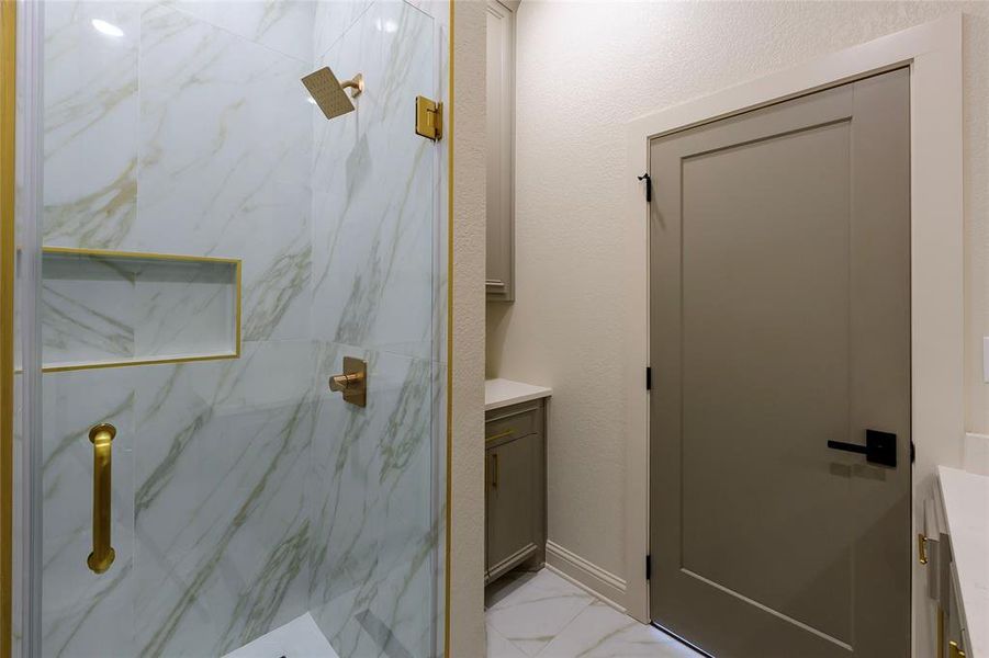 Full bathroom with vanity, a marble finish shower, and light marble finish flooring Full bathroom with vanity, a marble finish shower, and light marble finish flooring
