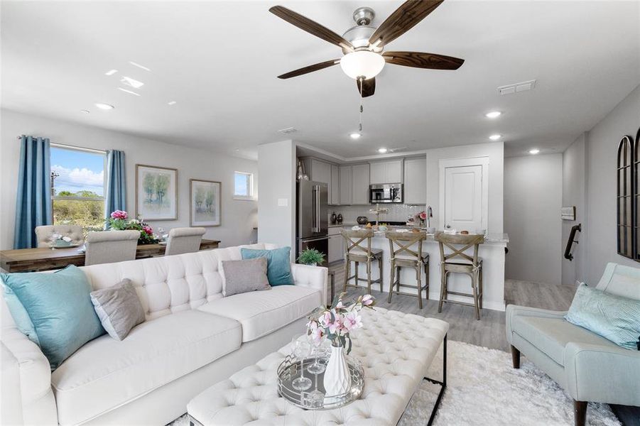 Living room with ceiling fan and light hardwood / wood-style floors