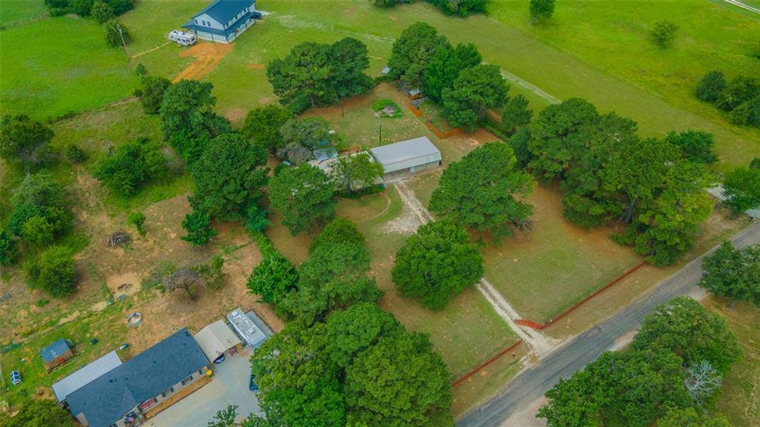 Aerial view highlighting the home's acreage, mature trees, workshop, and peaceful rural setting. Aerial view highlighting the home's acreage, mature trees, workshop, and peaceful rural setting.