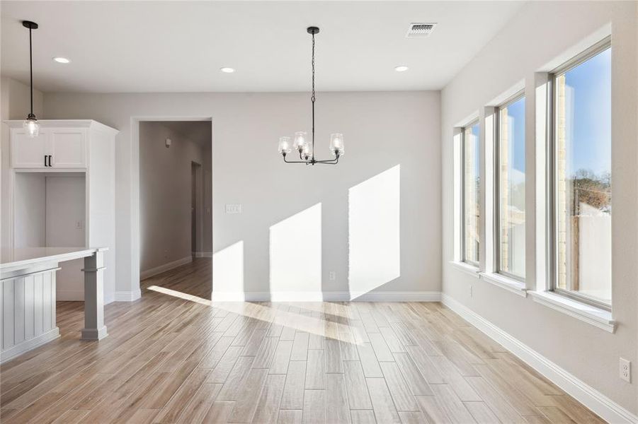 Unfurnished dining area with a wealth of natural light and a notable chandelier