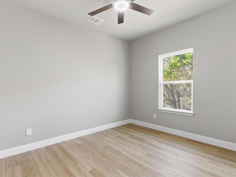 Spare room featuring light wood-style flooring and a ceiling fan Spare room featuring light wood-style flooring and a ceiling fan