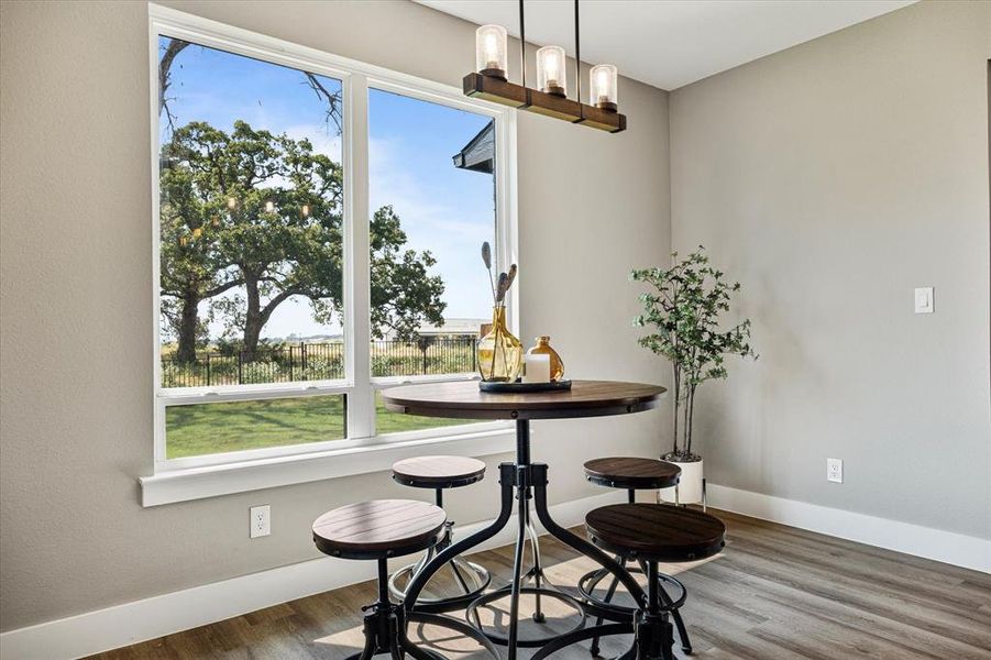 Dining area with hardwood / wood-style flooring and a notable chandelier