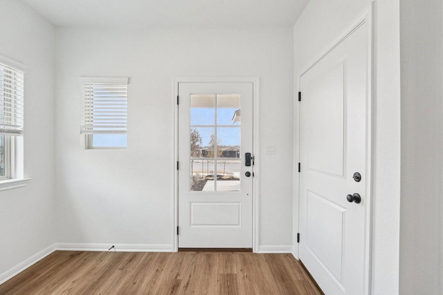 A well-lit entry with rich wood flooring welcomes you inside. A well-lit entry with rich wood flooring welcomes you inside.