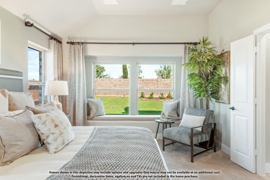 Bedroom with window seat, large backyard-facing windows, neutral bedding, and sitting area with gray accent chair Bedroom with window seat, large backyard-facing windows, neutral bedding, and sitting area with gray accent chair