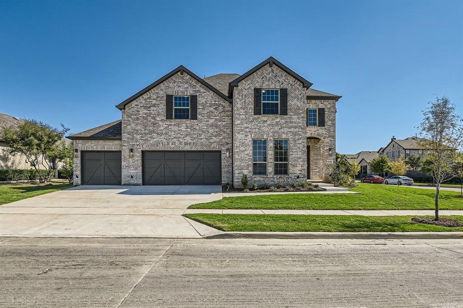 View of front of house with a front yard and a garage