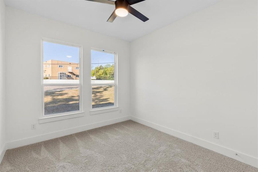 Carpeted spare room featuring ceiling fan