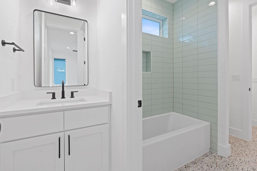 Full bath featuring vanity, speckled floor, and shower combination Full bath featuring vanity, speckled floor, and shower combination