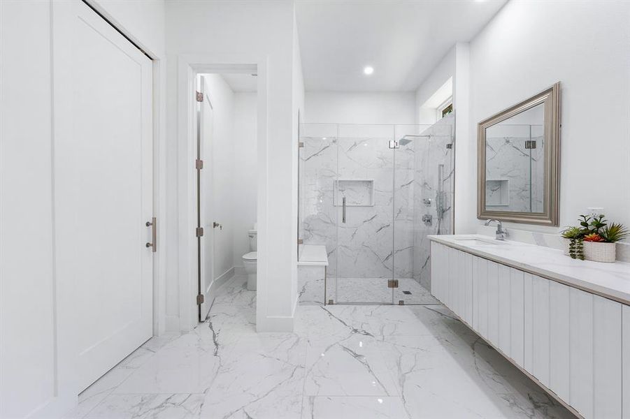 Bathroom featuring a marble finish shower, vanity, light marble finish floors, and recessed lighting Bathroom featuring a marble finish shower, vanity, light marble finish floors, and recessed lighting