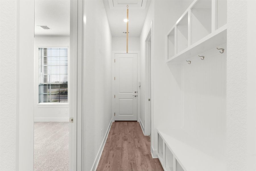 Mudroom featuring attic access and light wood finished floors