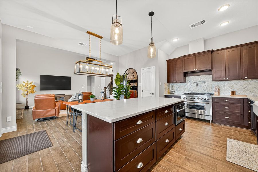 Open-concept design connects the kitchen seamlessly to the dining and living spaces, perfect for entertaining. Pendant lighting and rich cabinetry create a warm, sophisticated feel. Open-concept design connects the kitchen seamlessly to the dining and living spaces, perfect for entertaining. Pendant lighting and rich cabinetry create a warm, sophisticated feel.