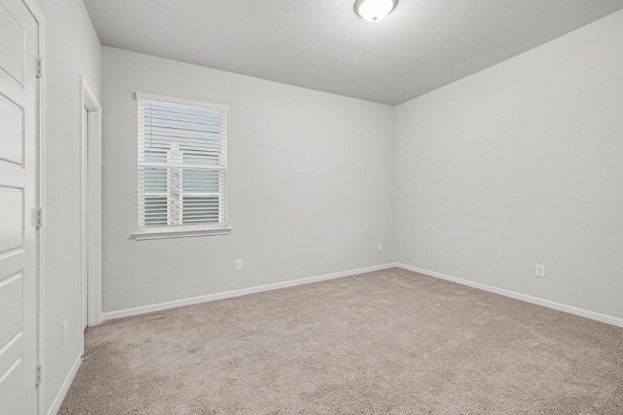Bedroom with soft carpet, closet access, and window overlooking the yard. Bedroom with soft carpet, closet access, and window overlooking the yard.