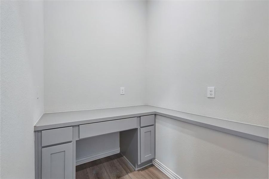 Unfurnished office with built in study area and dark wood finished floors Unfurnished office with built in study area and dark wood finished floors