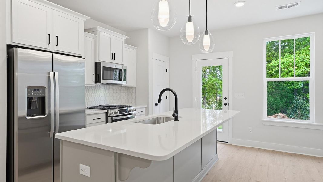 Exclusive kitchen design with large island, pendant lights, and tasteful finishes throughout located at Anna's Pointe