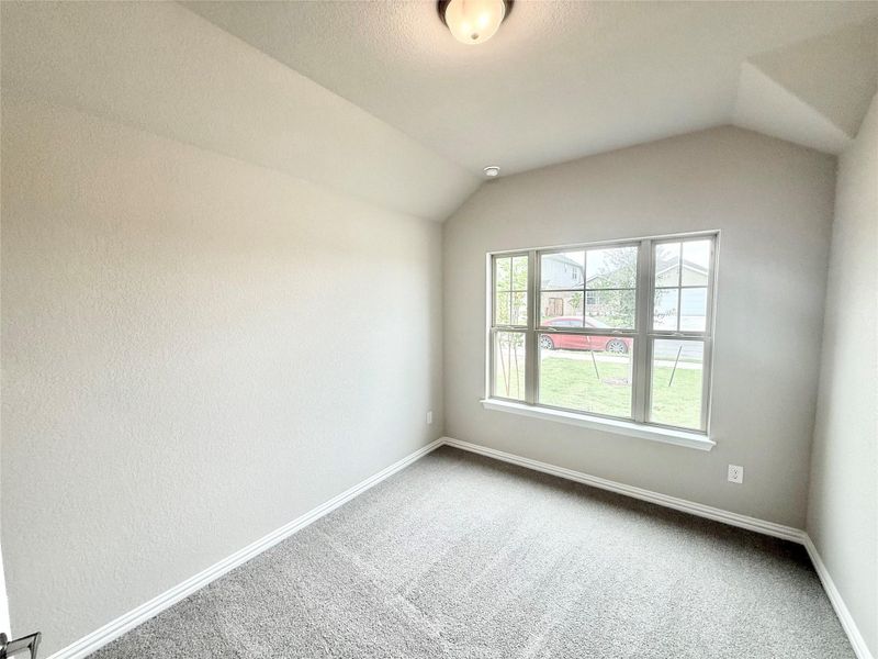 Carpeted empty room featuring lofted ceiling Carpeted empty room featuring lofted ceiling