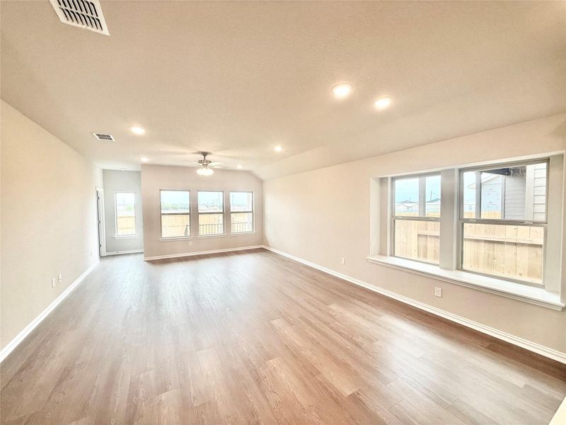 Unfurnished living room featuring plenty of natural light, light wood finished floors, vaulted ceiling, recessed lighting, and ceiling fan Unfurnished living room featuring plenty of natural light, light wood finished floors, vaulted ceiling, recessed lighting, and ceiling fan