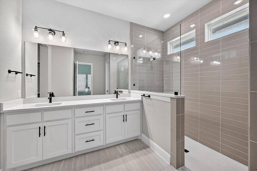 Double vanity featuring white cabinetry, integrated sinks, and matte black fixtures Double vanity featuring white cabinetry, integrated sinks, and matte black fixtures