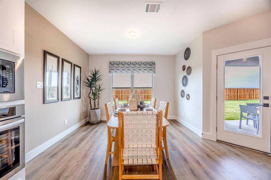 Dining room with light hardwood / wood-style floors and plenty of natural light