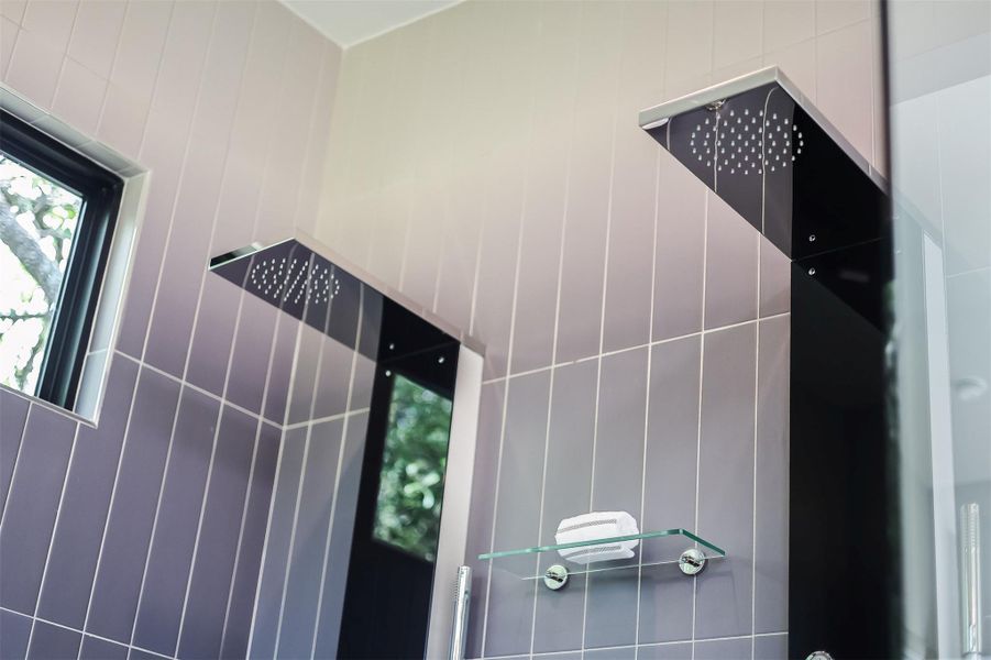 This is the reset point—a huge walk-in shower with dual showerheads and a frameless glass enclosure