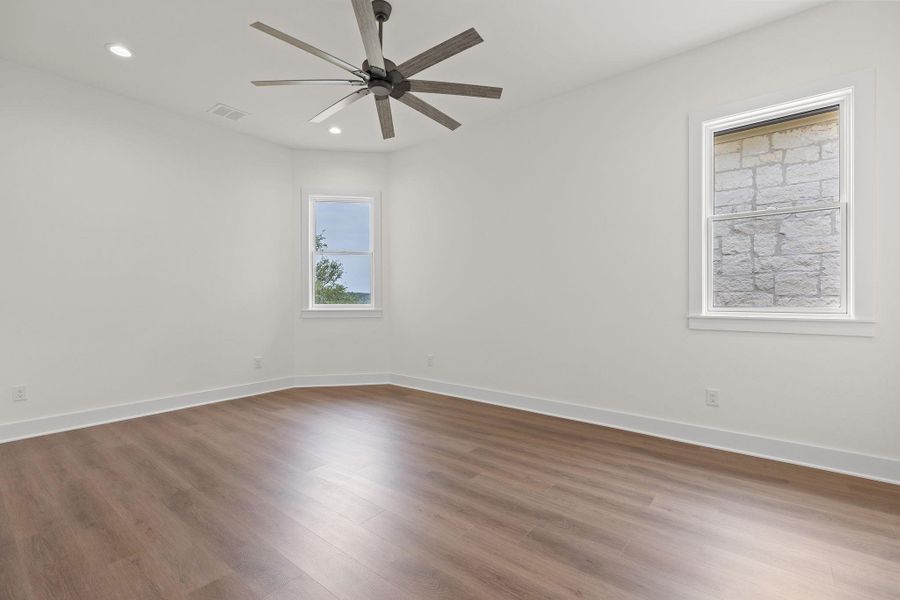 Unfurnished room with wood finished floors, a ceiling fan, recessed lighting, and baseboards Unfurnished room with wood finished floors, a ceiling fan, recessed lighting, and baseboards
