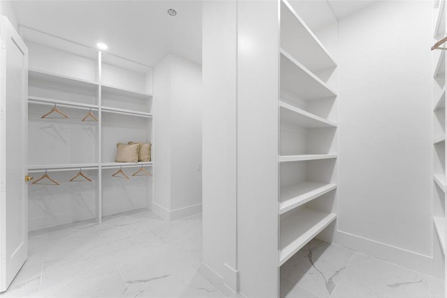 Spacious closet with light marble finish floors