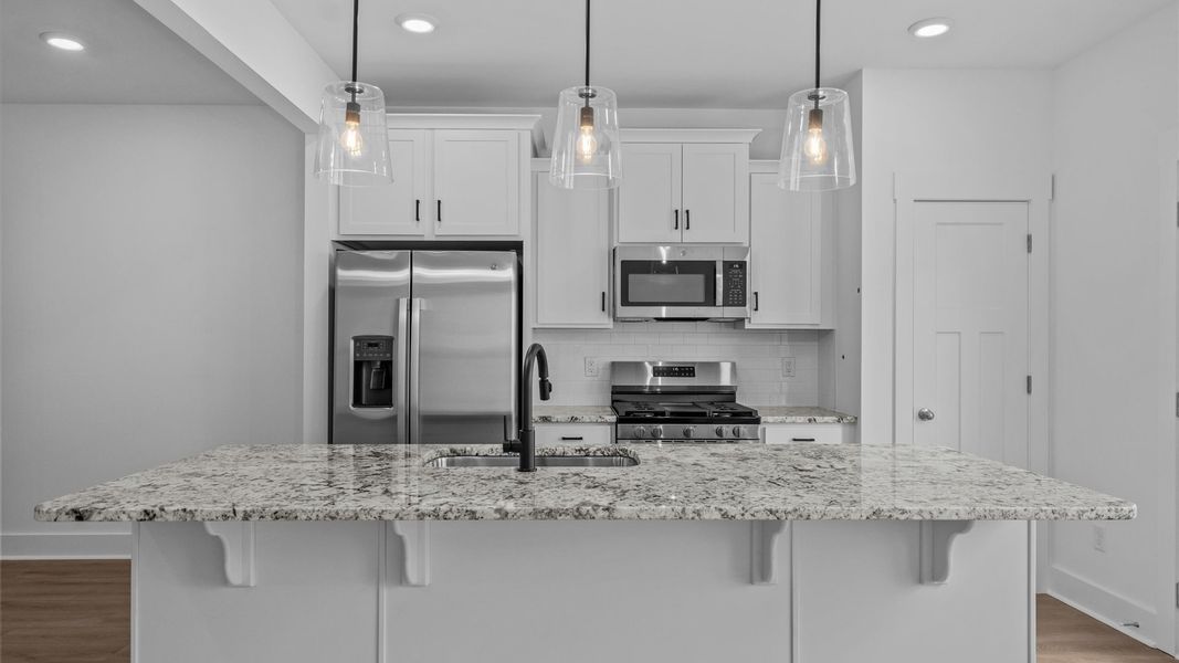 Highly skilled kitchen design includes a 9-foot island, granite countertops, and stylish pendant fixtures Highly skilled kitchen design includes a 9-foot island, granite countertops, and stylish pendant fixtures