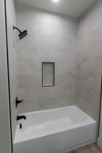 Full bath featuring wood finished floors and shower / washtub combination