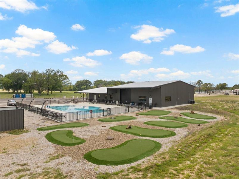 Community pool with a patio area and a putting green