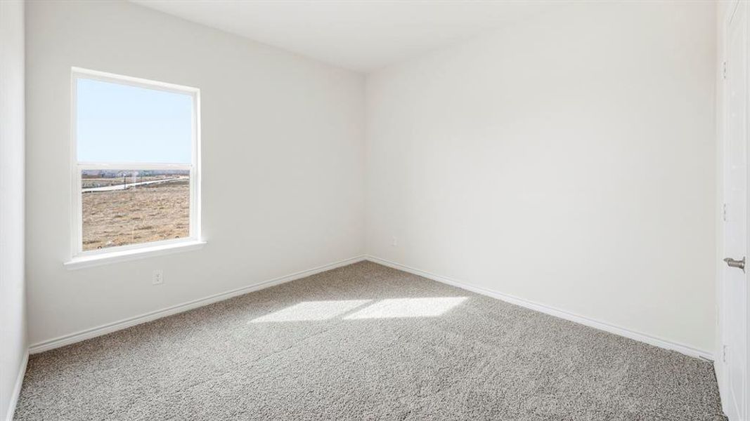 Unfurnished room featuring light carpet and baseboards