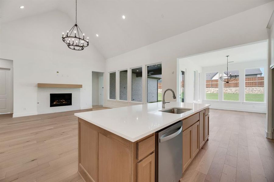 Kitchen featuring a chandelier, hanging light fixtures, light wood-style flooring, open floor plan, and light brown cabinetry