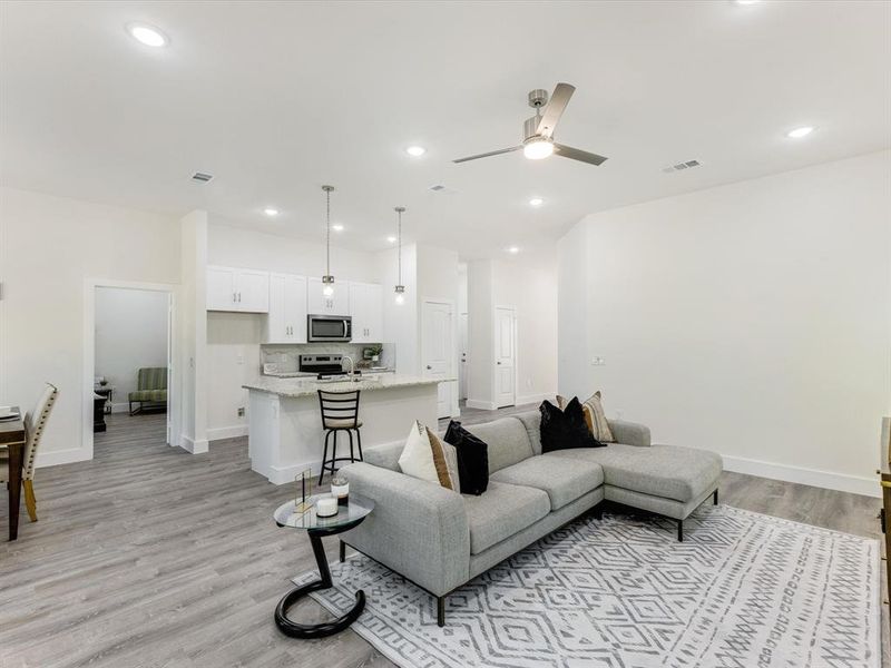 Living area featuring light wood finished floors, recessed lighting, and a ceiling fan