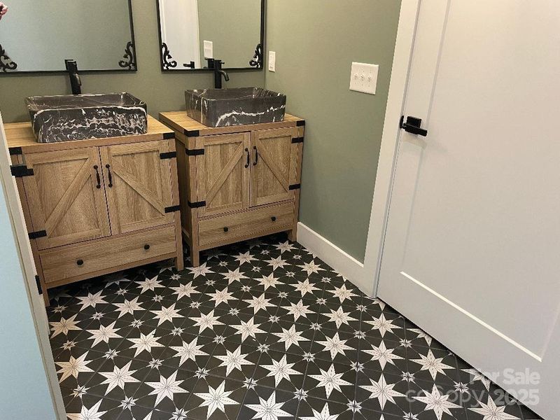 Hall Bath double vanity accented by the custom laid tile floor