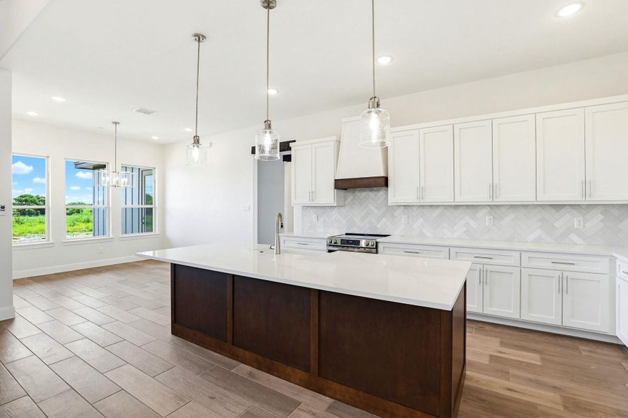 A well-appointed kitchen features a large island and ample cabinetry, offering abundant space for culinary endeavors.
